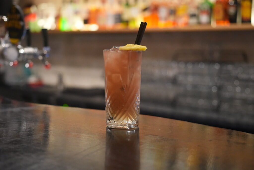 Iced cocktail with lemon on bar counter
