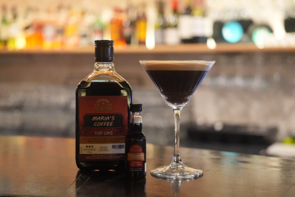 Coffee liqueur bottle and cocktail on bar counter